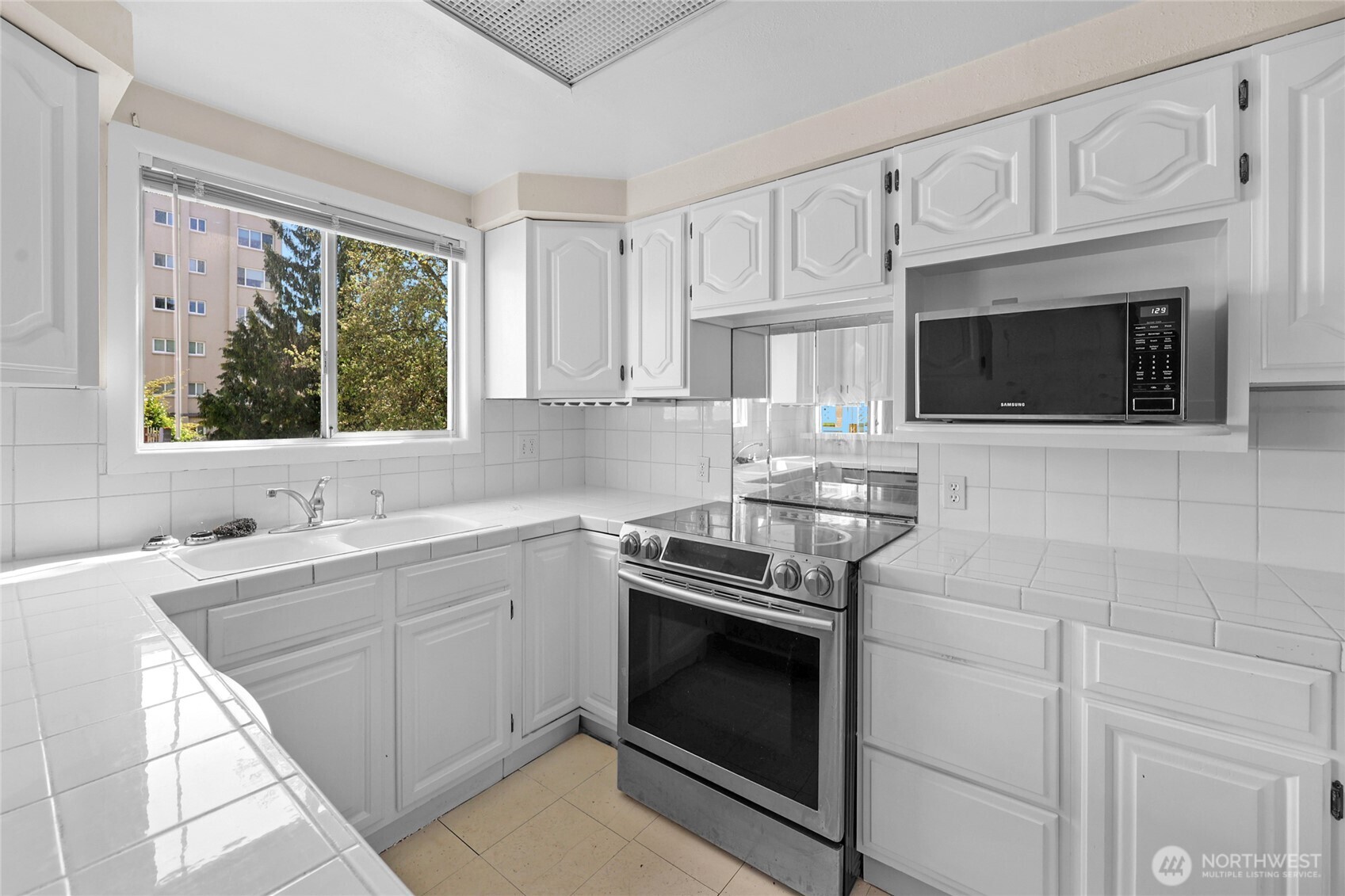 924 3rd Avenue West Seattle, WA 98119 - Photo 8 of 18 a kitchen with cabinets stainless steel appliances a sink and a window