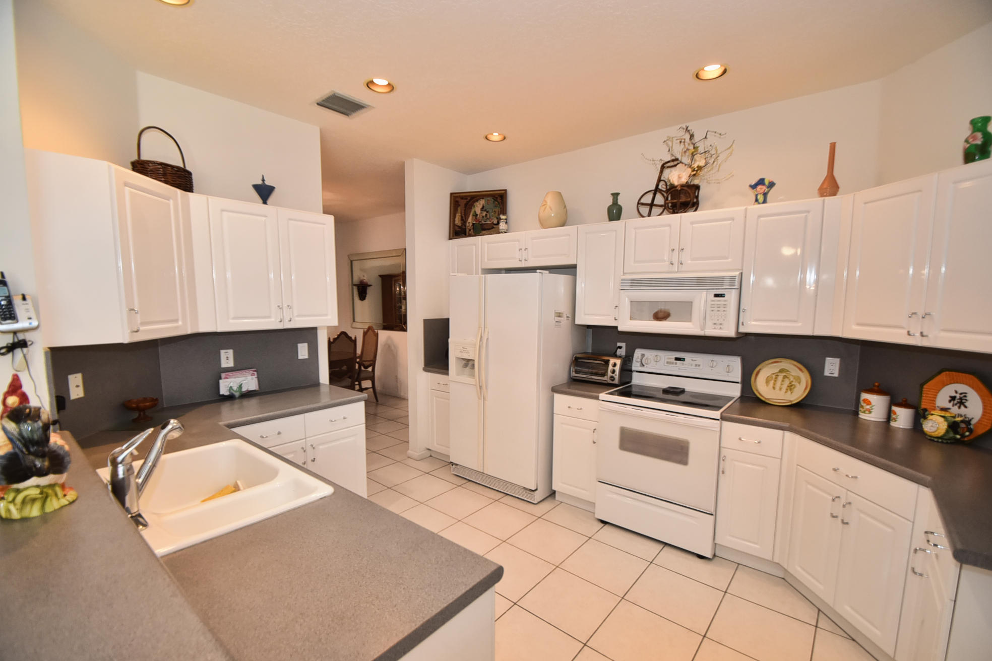 5916 Seashell Terrace Boynton Beach, FL 33437 - Photo 12 of 31 a kitchen with stainless steel appliances a stove a refrigerator and white cabinets