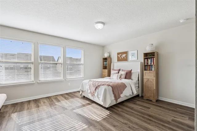 a spacious bedroom with a bed and a large window