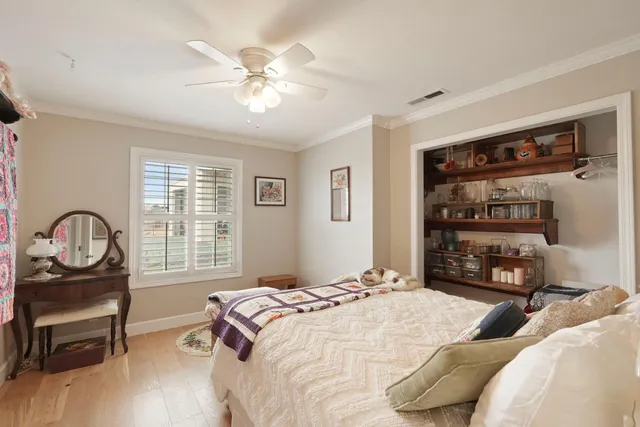 a bedroom with a bed a dresser and a chandelier