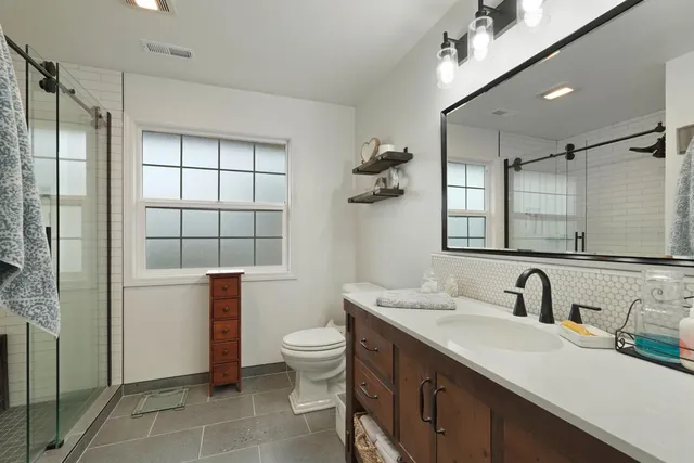 a bathroom with a double vanity sink toilet and shower