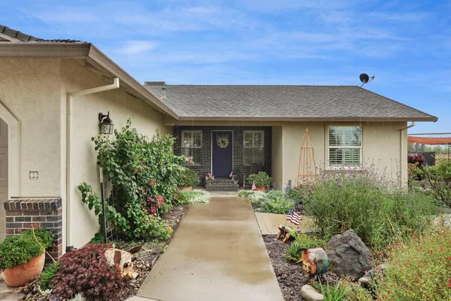 a view of a house with backyard and trees