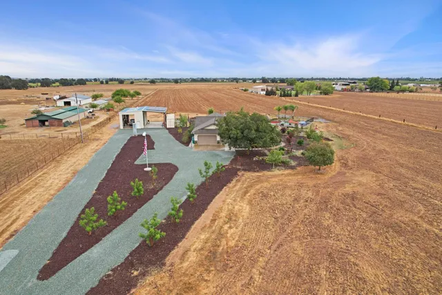 an aerial view of a house with a garden and lake view