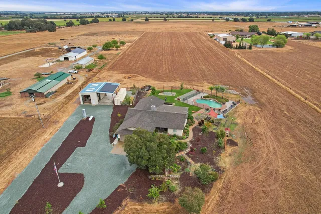 an aerial view of residential houses with outdoor space and ocean view