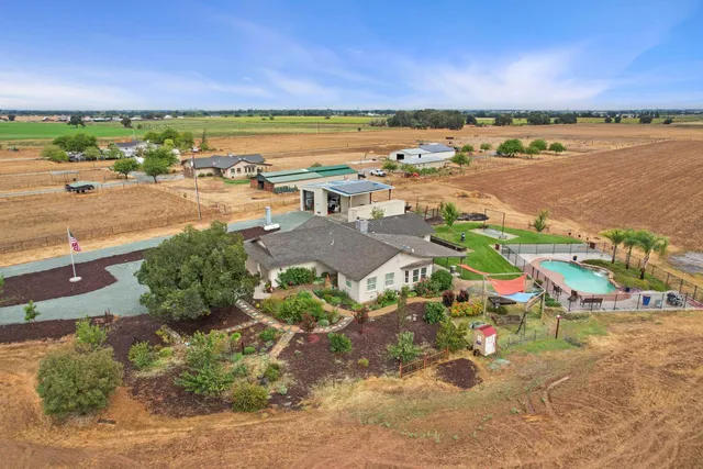 an aerial view of a house with a garden and lake view