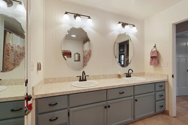 a bathroom with double vanity sinks and a mirror