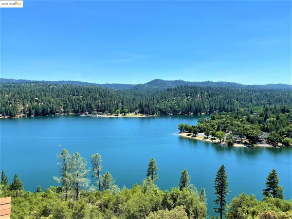 an aerial view of residential houses with outdoor space and lake view