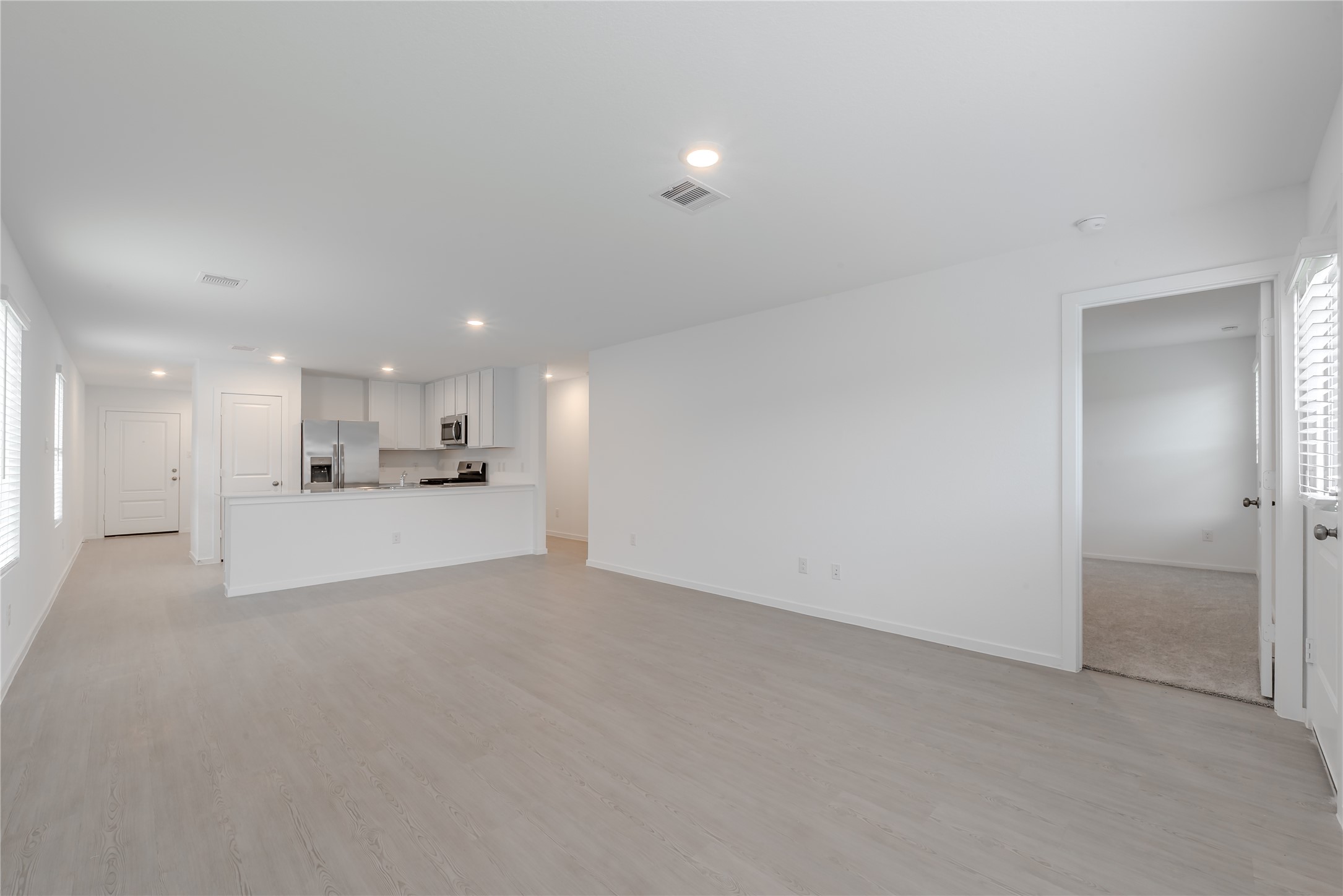 21358 Offida Lane New Caney, TX 77357 - Photo 12 of 26 a view of a kitchen with white cabinets and stainless steel appliances