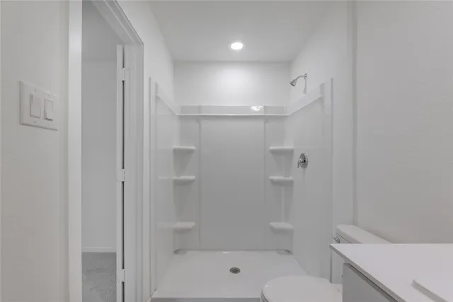a bathroom with a shower a toilet and sink