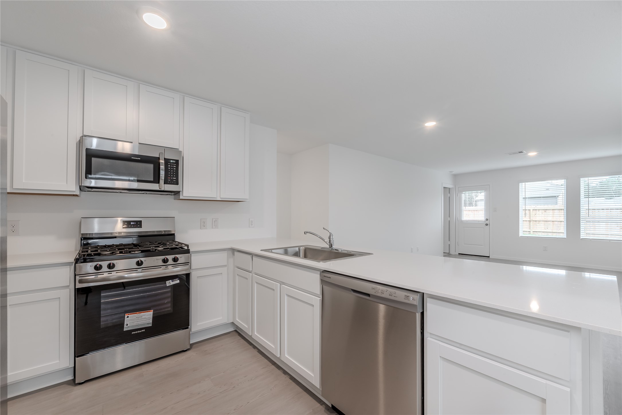 21358 Offida Lane New Caney, TX 77357 - Photo 8 of 26 a kitchen with a sink stove and microwave