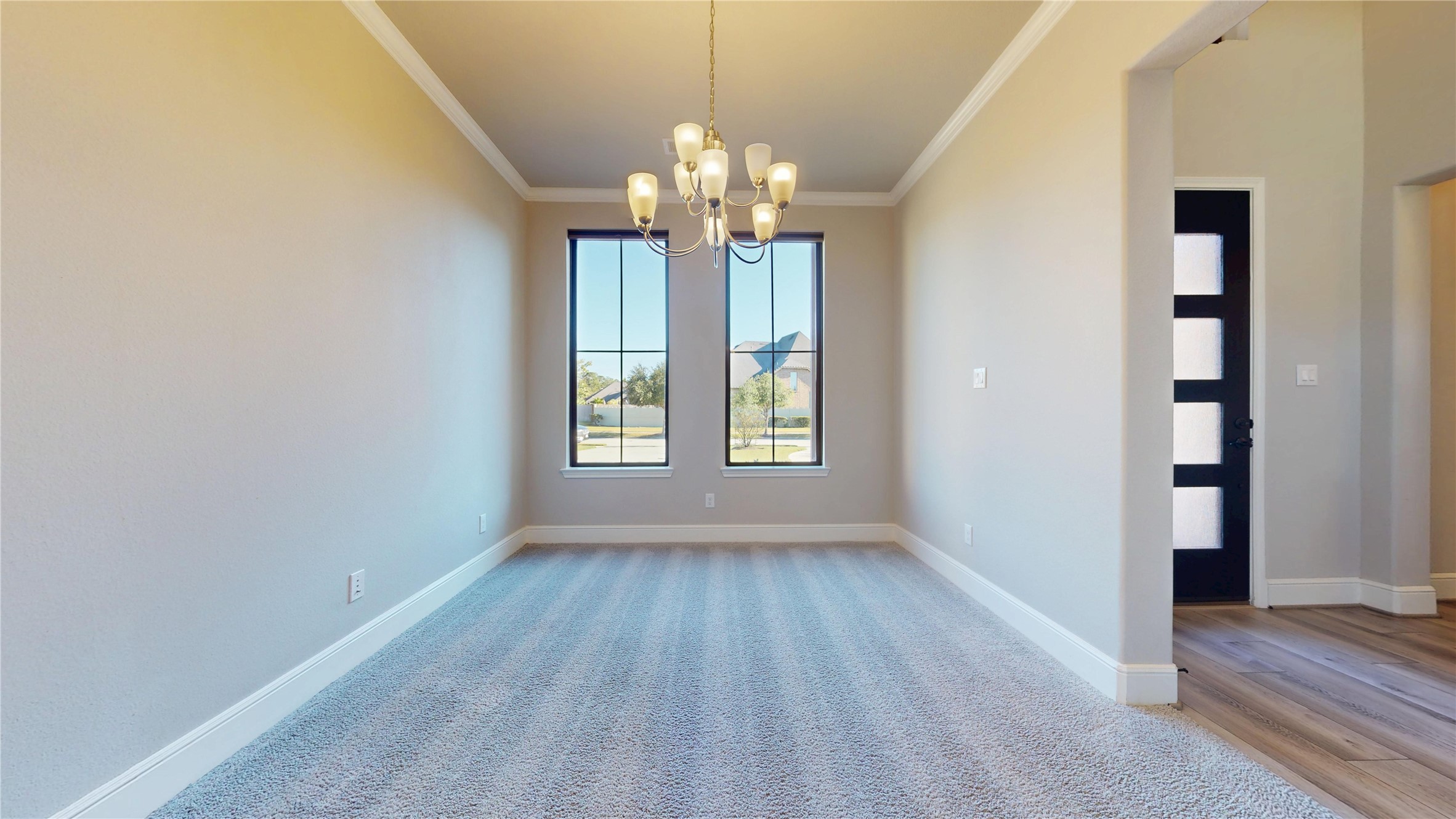 8305 Greenleaf Ridge Way Conroe, TX 77385 - Photo 6 of 33 a view of a hallway with wooden floor and a chandelier
