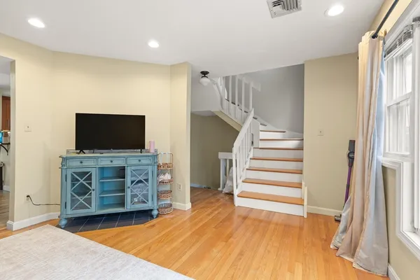 a view of room with wooden floor and flat screen tv