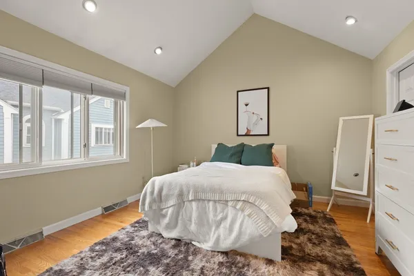 a bedroom with a bed and wooden floor