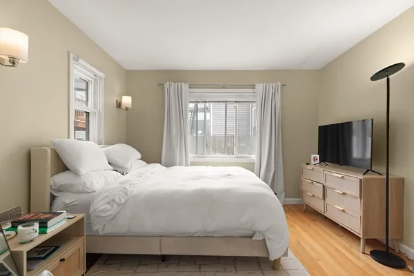a bedroom with a bed and a flat tv screen on wall