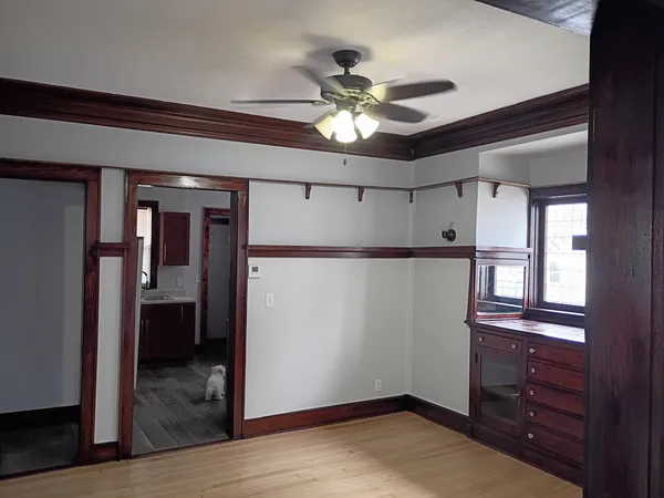 a view of a hallway with wooden floor and a chandelier