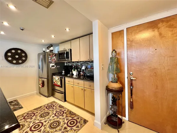 a kitchen with stainless steel appliances granite countertop a refrigerator and a stove top oven