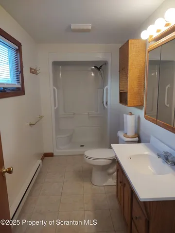 a bathroom with a sink a toilet and shower