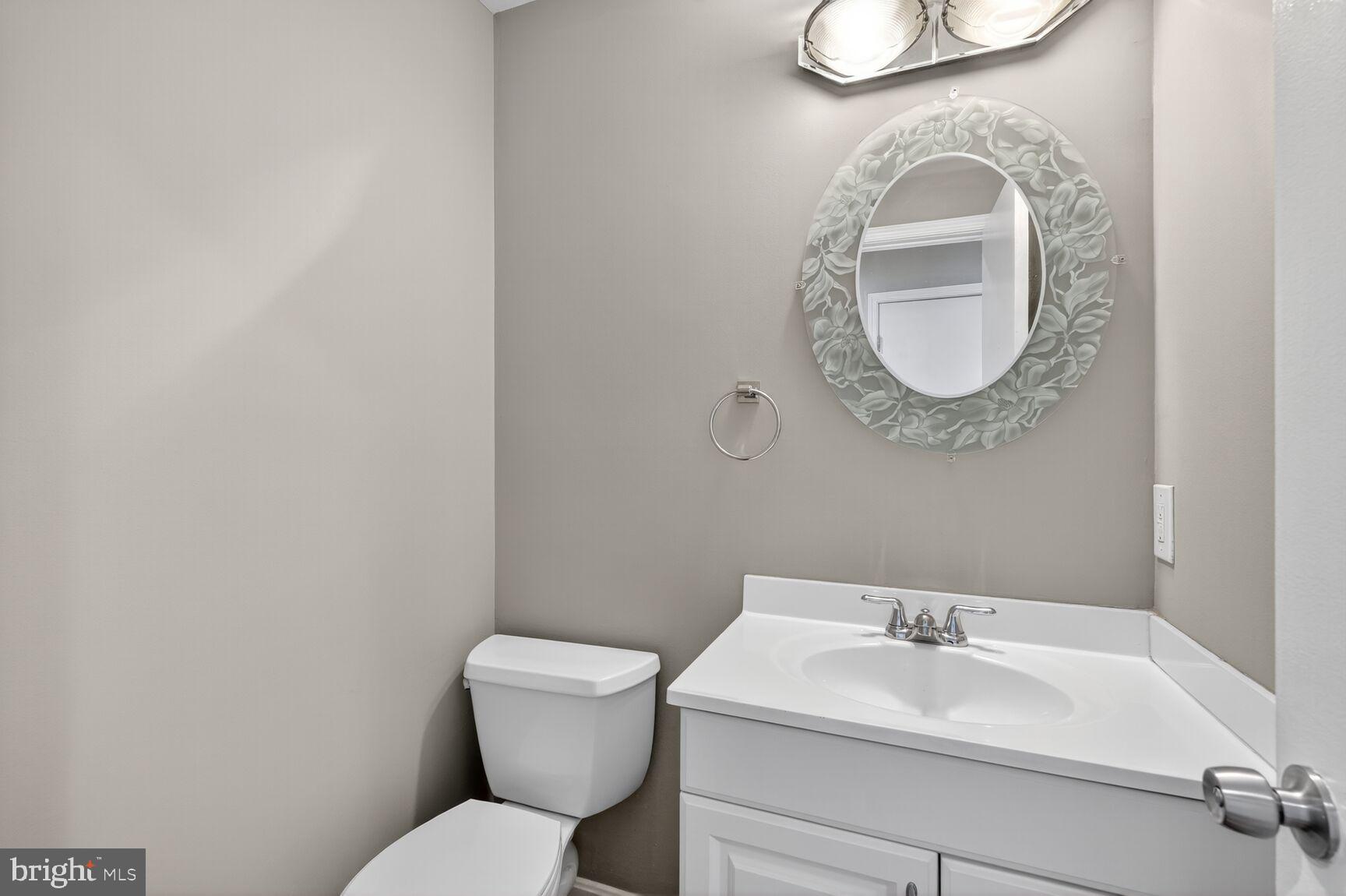 7310 Eggar Woods Lane Springfield, VA 22153 - Photo 14 of 29 a bathroom with a toilet sink vanity and mirror