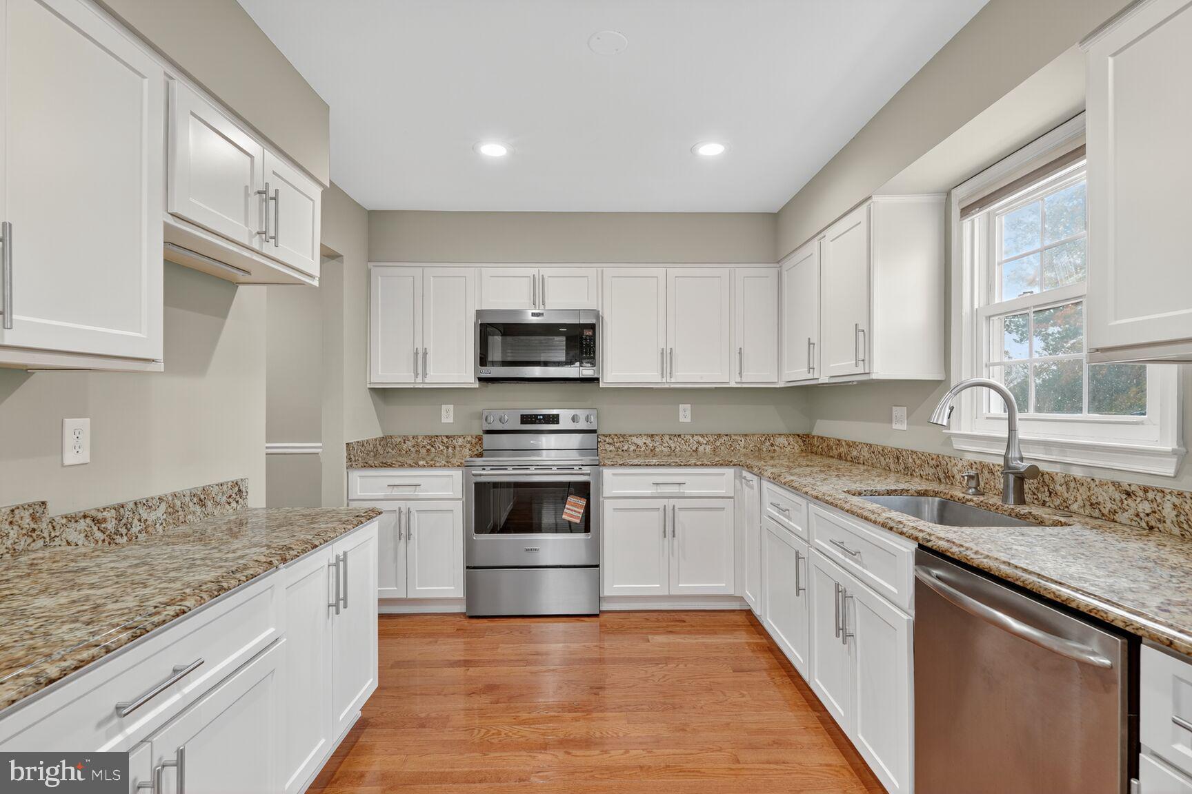 7310 Eggar Woods Lane Springfield, VA 22153 - Photo 8 of 29 a kitchen with stainless steel appliances granite countertop a sink stove and refrigerator