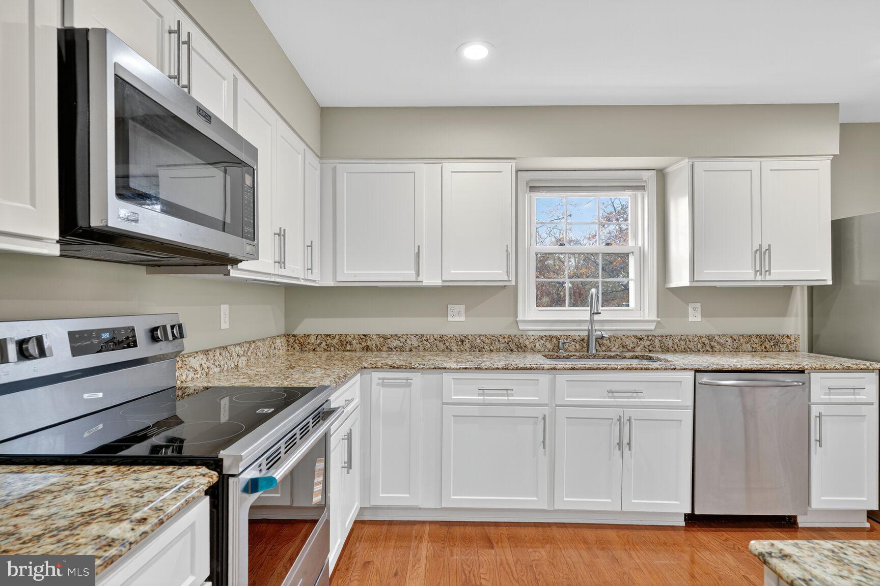 7310 Eggar Woods Lane Springfield, VA 22153 - Photo 9 of 29 a kitchen with stainless steel appliances granite countertop a stove a sink and a microwave