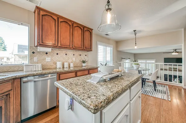 a kitchen with a table chairs a sink dishwasher window and cabinets