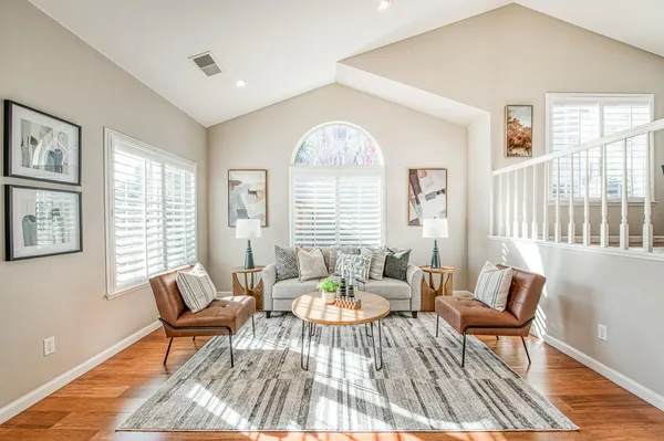 a living room with furniture a table and a large window