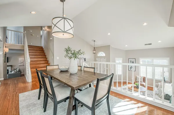 a kitchen with stainless steel appliances granite countertop a stove a sink dishwasher and white cabinets with wooden floor