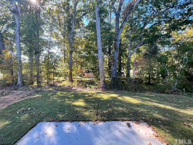 a view of a yard with large trees