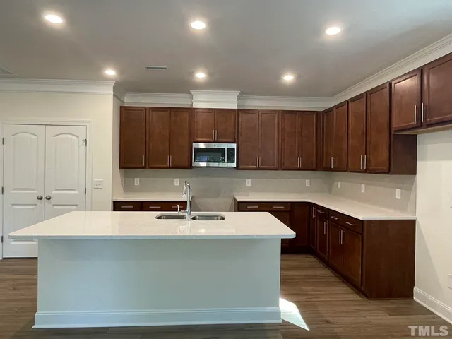 a kitchen with kitchen island granite countertop wooden cabinets a sink and dishwasher