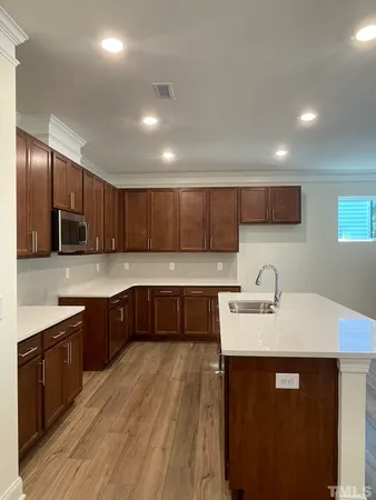 a kitchen with a sink cabinets and wooden floor