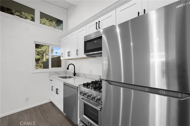 a kitchen with stainless steel appliances granite countertop a refrigerator and a sink