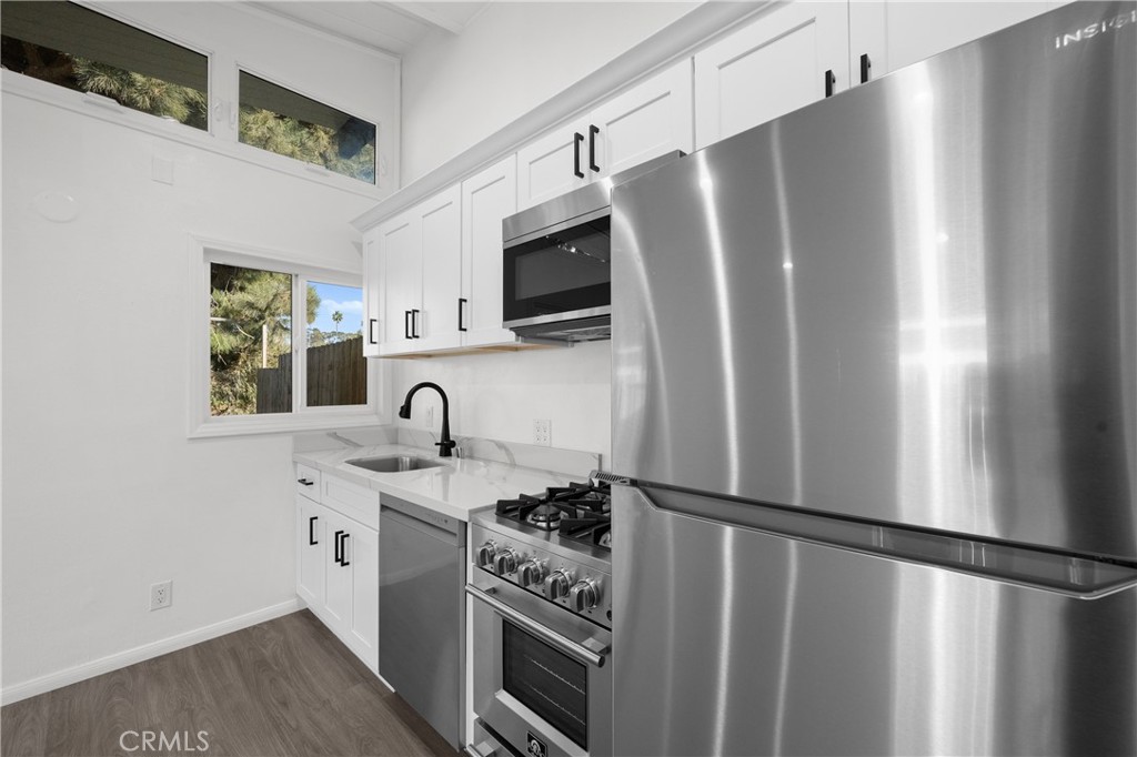a kitchen with stainless steel appliances granite countertop a refrigerator and a sink