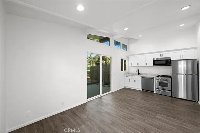 a large kitchen with stainless steel appliances a refrigerator and a stove top oven