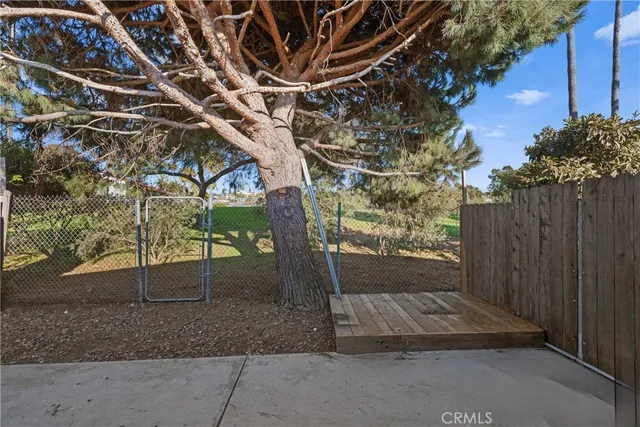 a view of backyard with wooden fence