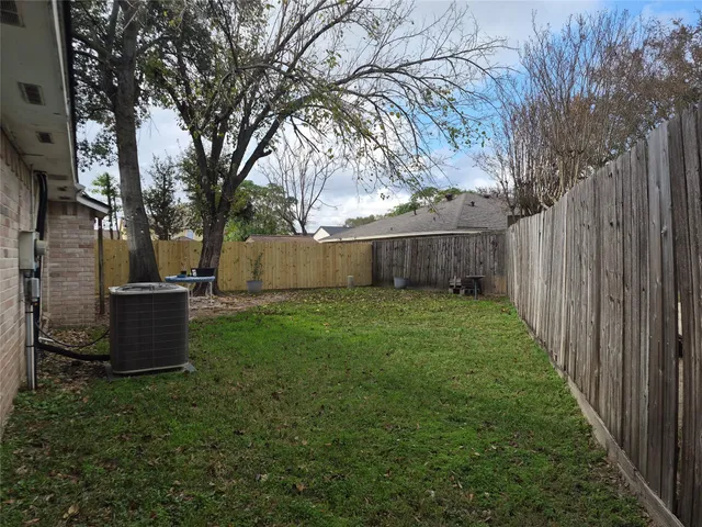 a view of a backyard with potted plants and large trees