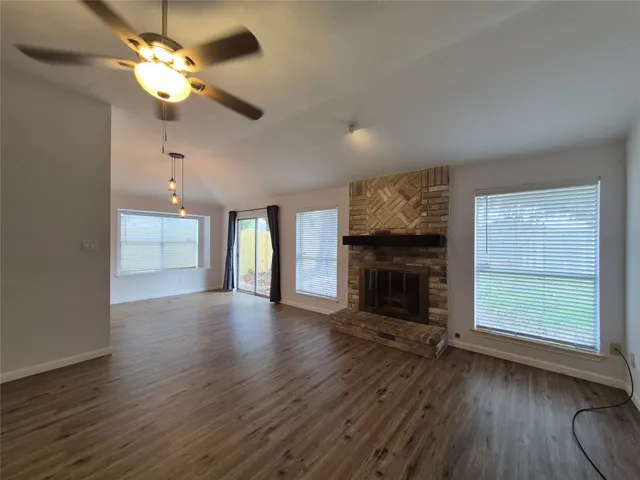 a view of an empty room with a fireplace and a window