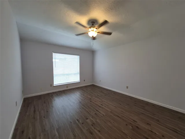 a view of wooden floor and chandelier fan in a room