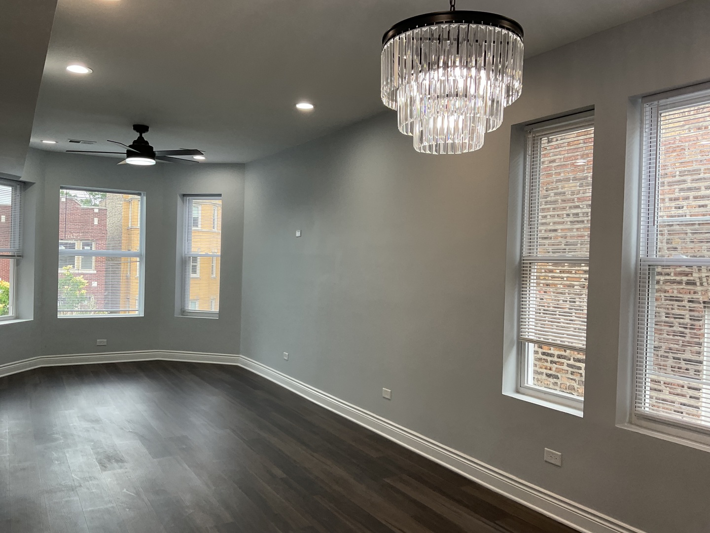 7940 South Carpenter Street, Unit 2 Chicago, IL 60620 - Photo 6 of 34 an empty room with wooden floor chandelier fan and windows