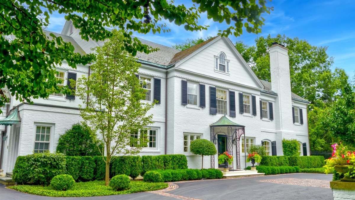 a front view of a house with a yard and potted plants