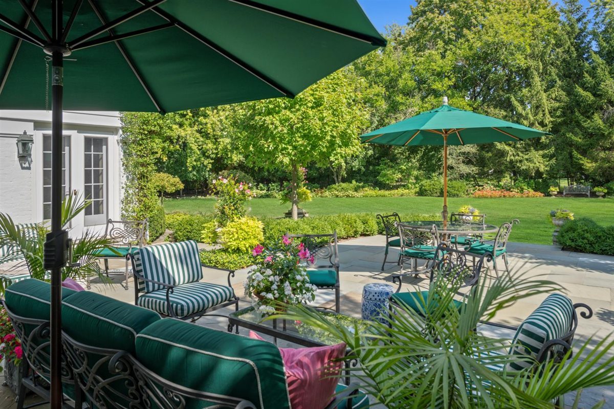5 Woodley Road Winnetka, IL 60093 - Photo 13 of 48 a view of a patio with couches table and chairs under an umbrella
