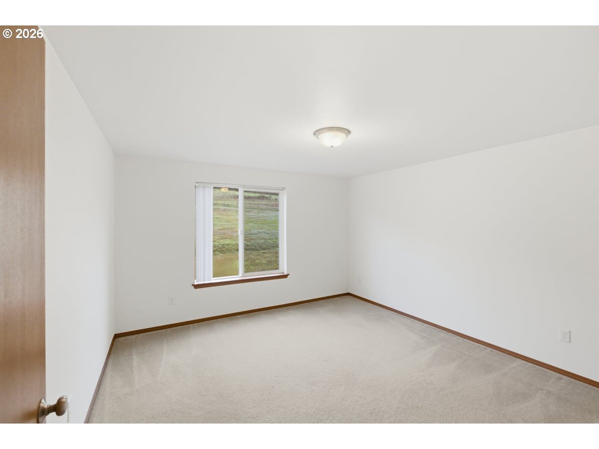37905 South Wilhoit Road Molalla, OR 97038 - Photo 22 of 48 a view of an empty room with wooden floor and a window