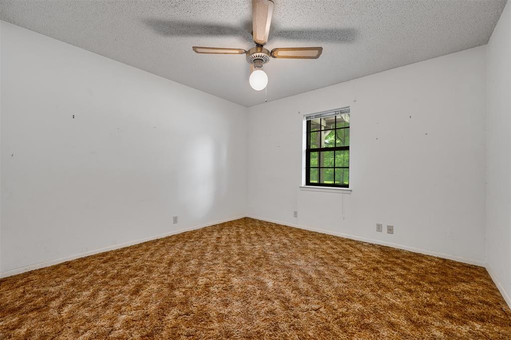 8798 Hill N Dale Road Tyler, TX 75709 - Photo 19 of 31 Neutral white walls with textured ceiling and brown shag carpet