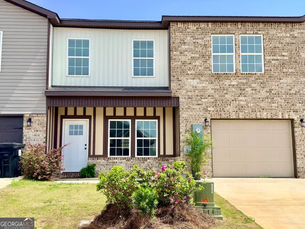 front view of a brick house with a yard