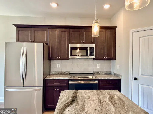 a kitchen with stainless steel appliances granite countertop a refrigerator and a stove