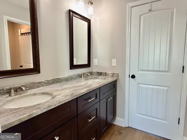 a bathroom with a granite countertop sink and a mirror
