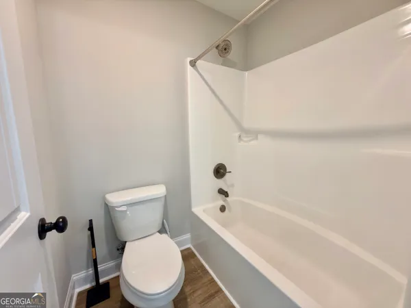 a white toilet sitting next to a bathtub