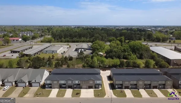 an aerial view of multiple houses with a yard