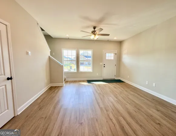an empty room with wooden floor and windows