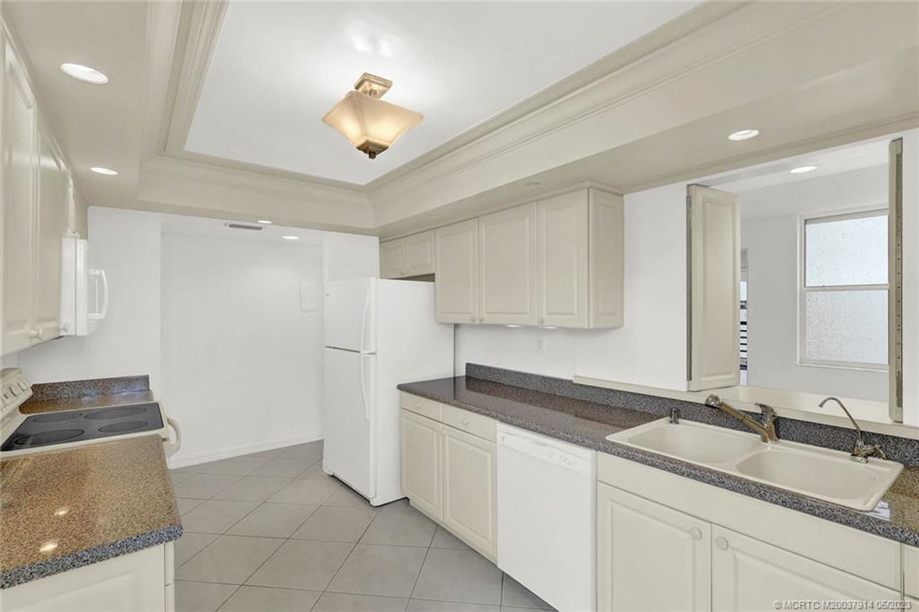 1950 Southwest Palm City Road, Unit 14207 Stuart, FL 34994 - Photo 16 of 50 a kitchen with a sink and a stove top oven with wooden floor