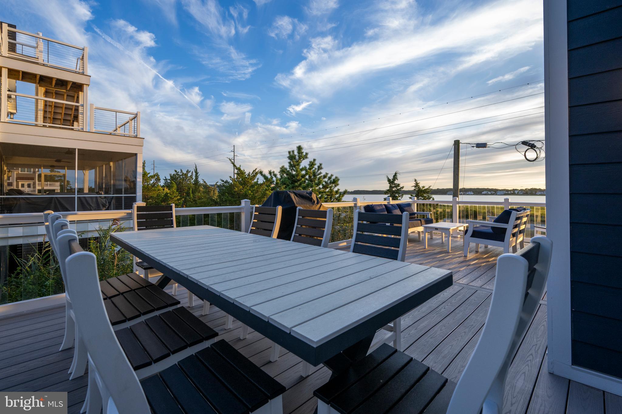 39546 Admiral Road Bethany Beach, DE 19930 - Photo 61 of 73 a view of a roof deck with table and chairs a barbeque with wooden floor and fence